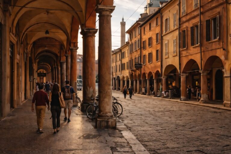 Bologna historic center with red porticoes, arcades, and people walking in late afternoon light.