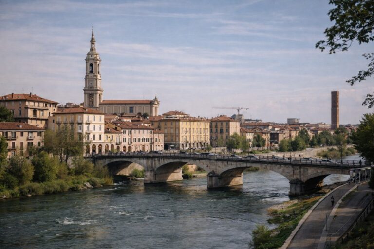 Alessandria cityscape along the Tanaro river with bridge and historic buildings