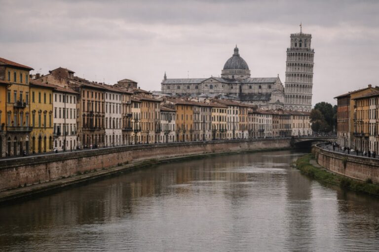 Pisa skyline with the Leaning Tower and Arno River under overcast light.