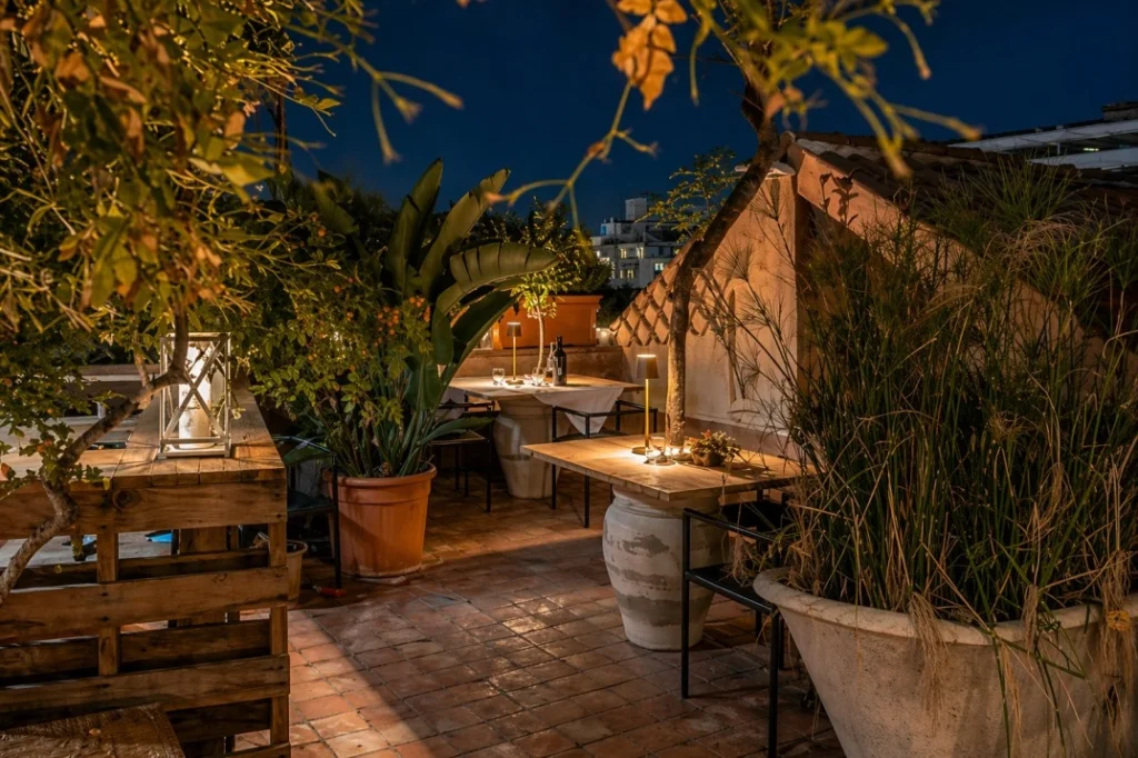 Rooftop terrace at Casa D’Aria in Catania with Mediterranean plants, warm lighting and outdoor dining spaces