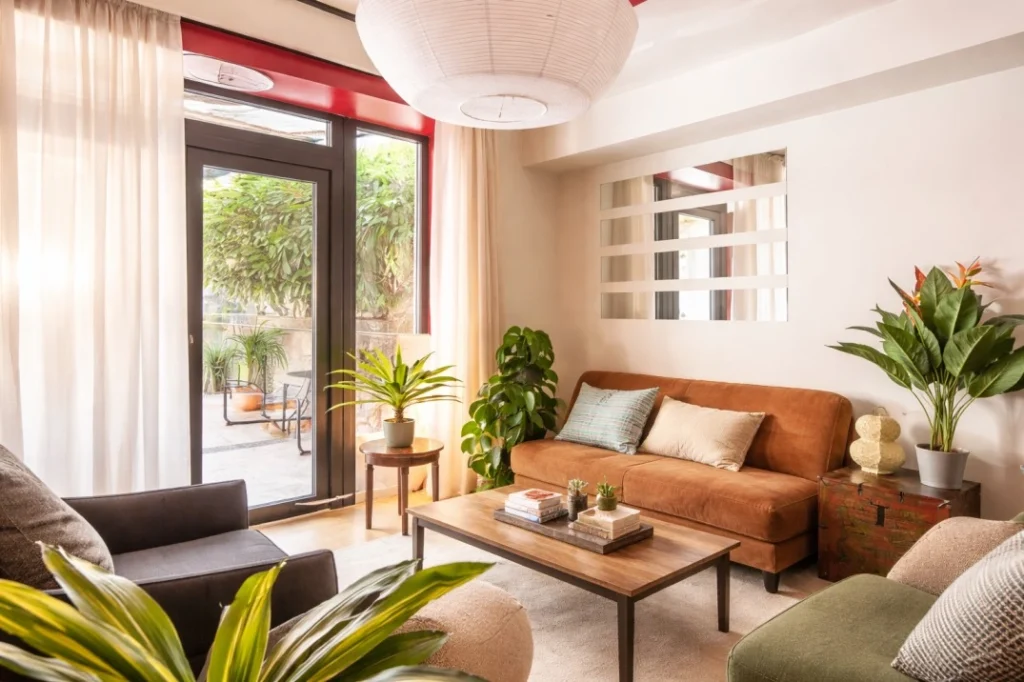Cohabs Dateo Milan shared living space with sofa, plants, and natural daylight from terrace
