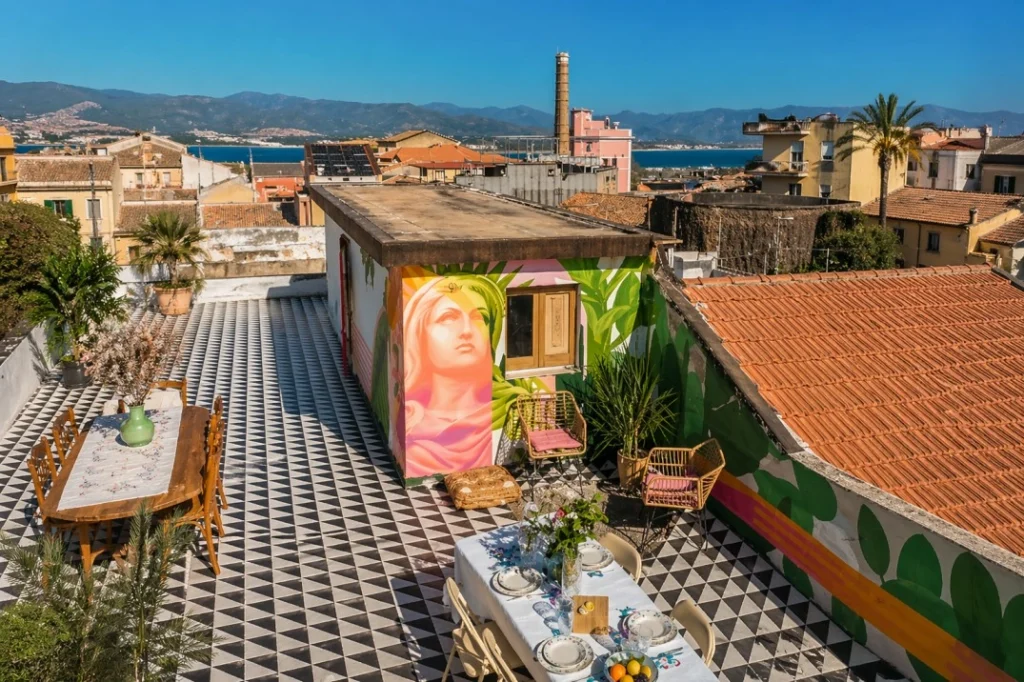 Cummari coliving rooftop terrace in Catania with sea views, communal dining area and colorful Mediterranean design