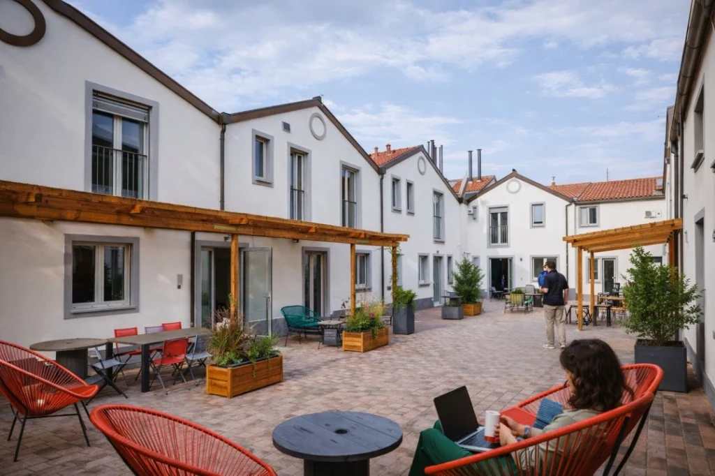 Eco-living Milano Navigli courtyard with residential units, shared outdoor seating, and everyday use