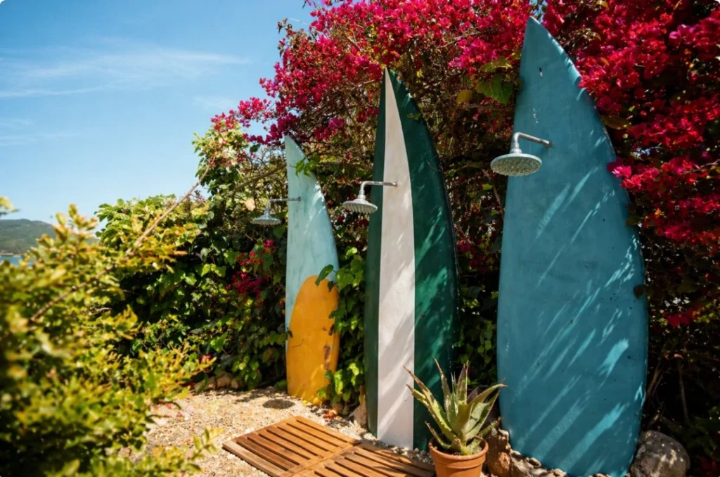 Surf-inspired outdoor shower area at Floripa coliving surrounded by tropical Mediterranean vegetation