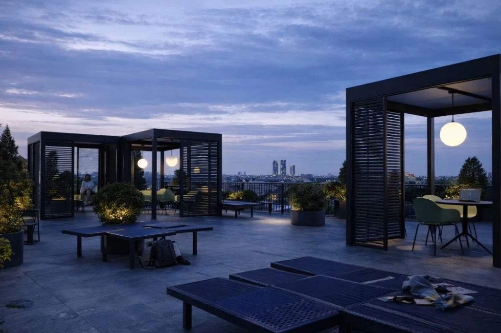Rooftop terrace at Homizy Tucidide Milan with pergolas, seating areas and city skyline at dusk