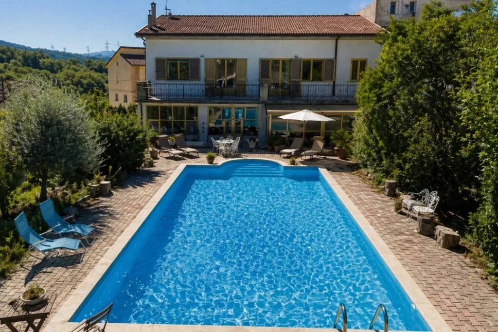 La Vita Sukha coliving in Italy with outdoor pool and villa surrounded by greenery