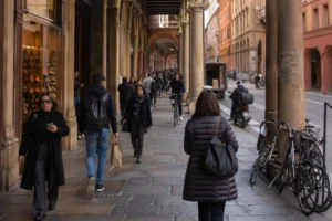 Living in Bologna, Italy – people walking under central porticoes on a normal day