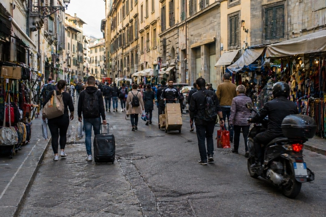 Santa Maria Novella in Florence, Italy – station-market street with pedestrians and luggage