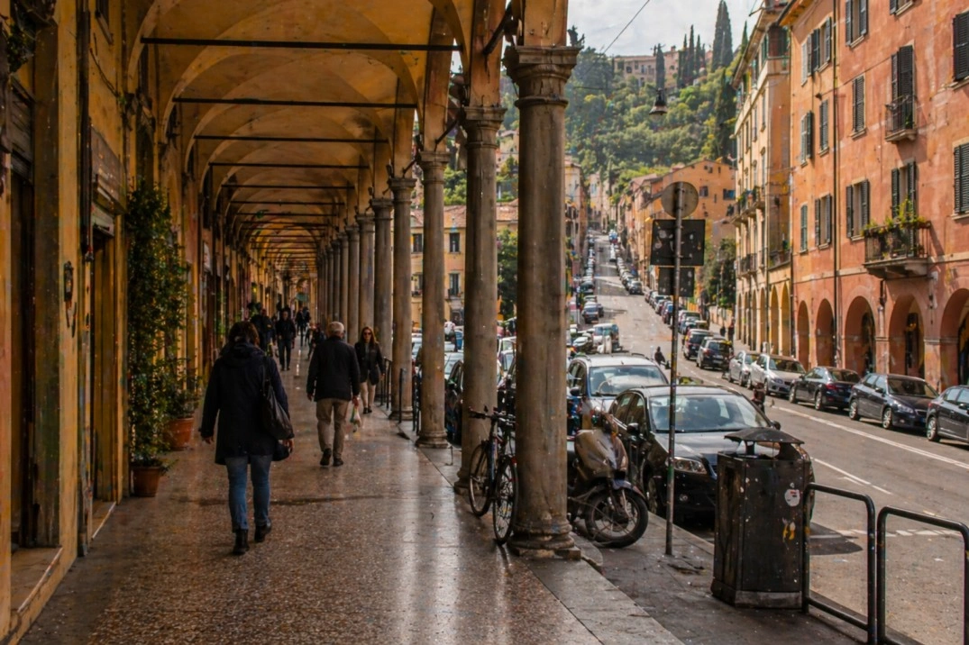 Saragozza in Bologna, Italy – residential portico route with walkers and parked cars