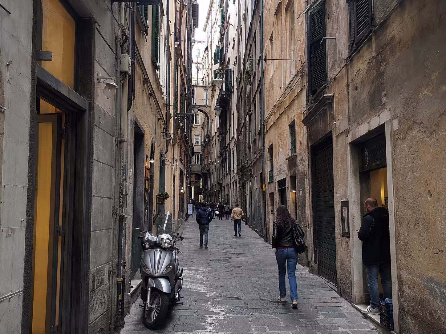 Centro Storico Genova, Italy – narrow caruggio with pedestrians and old buildings